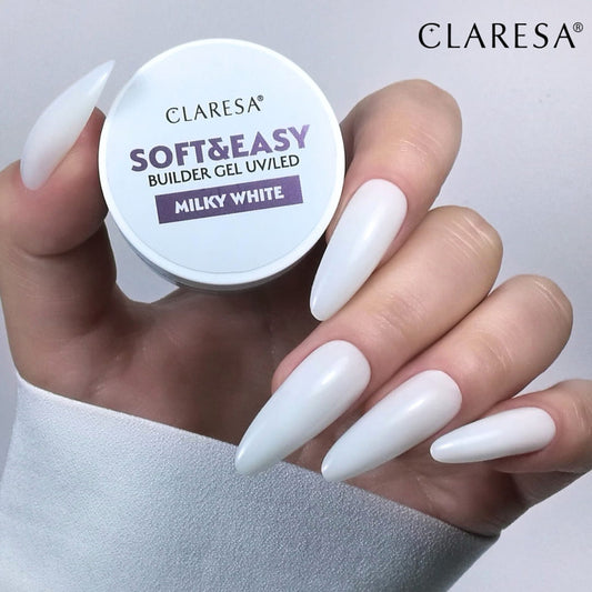 Claresa Soft & Easy Builder Gel UV/LED container held by a hand with white nails on a gray background